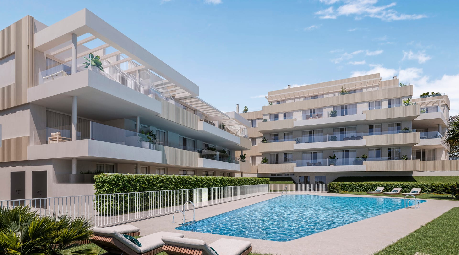 The shared pool, with loungers on the lawn and the terraces of the apartments rising behind it. Zenith Estepona, El Calvario, Estepona.