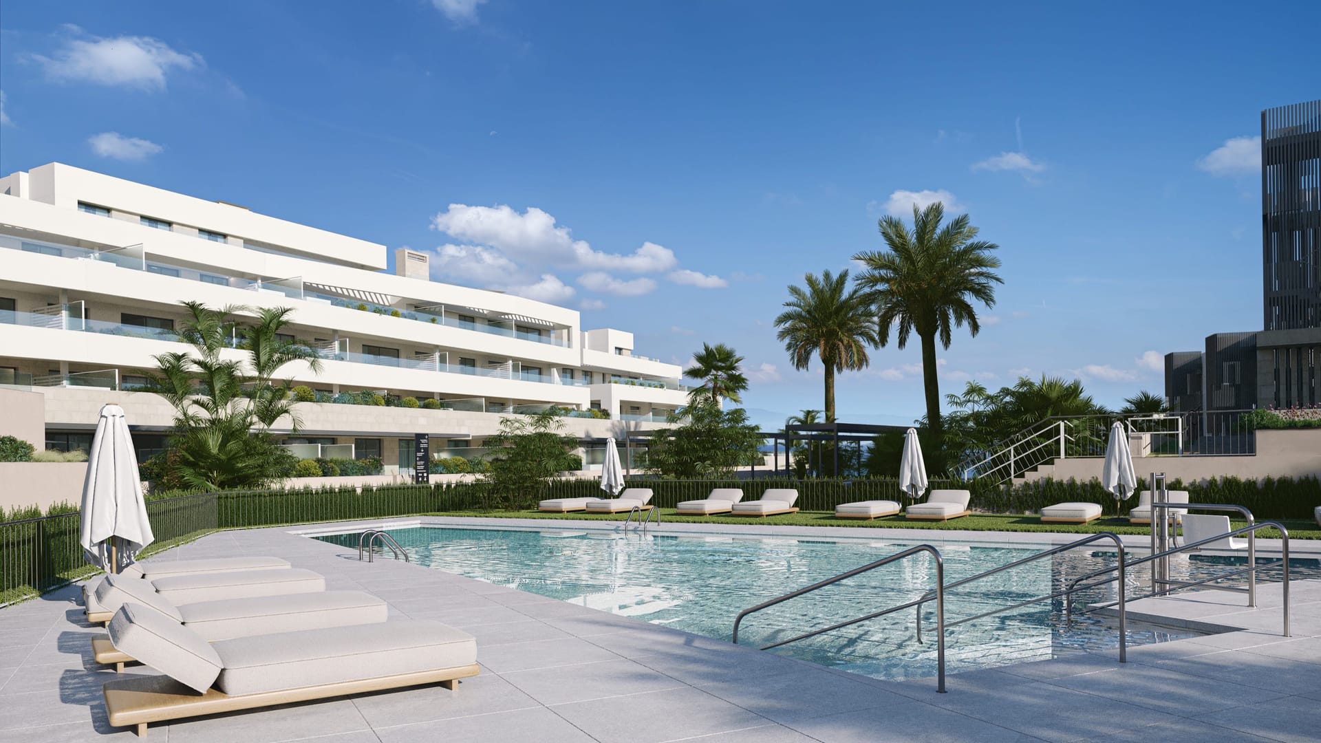 A pool edged with sun loungers and palm trees, with the white apartment buildings behind. Zenity Blau I, La Gaspara, Estepona.