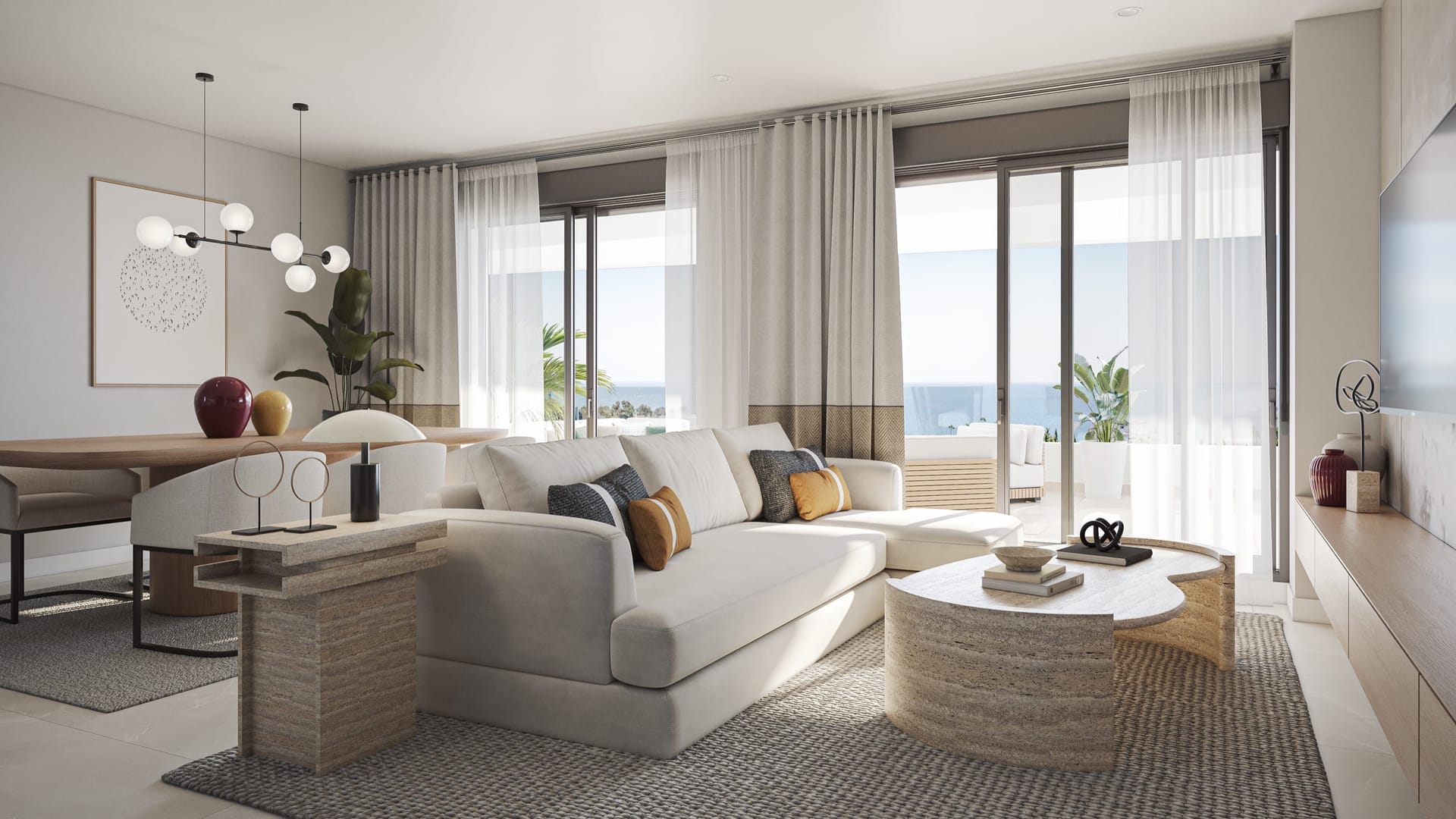 A living room with an L-shaped sofa and a round coffee table, and tall windows onto the terrace. Zenity Blau I, La Gaspara, Estepona.