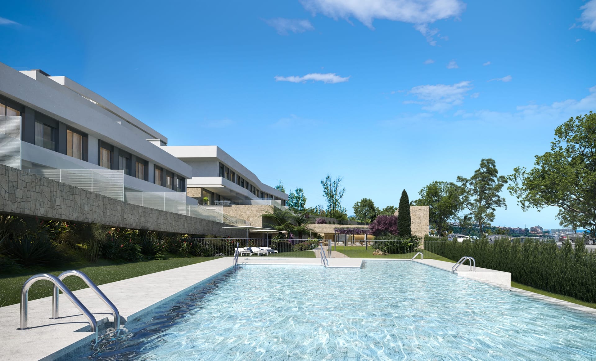 The pool in front of the buildings, with sun loungers on the lawn at its far end. Zenity Indigo, La Gaspara, Estepona.