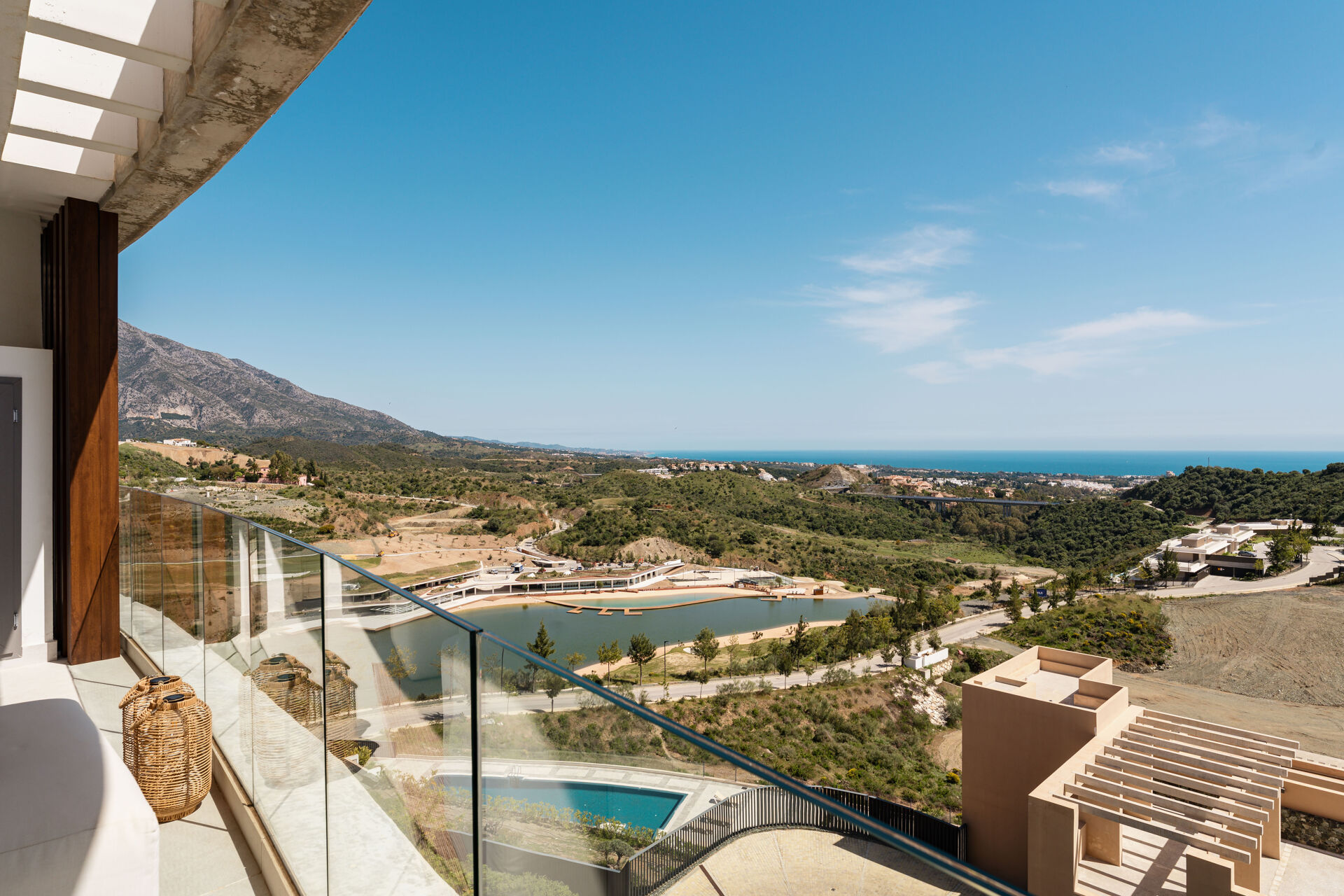 The view from the terrace over a lake and wooded hills to the mountains and the sea.