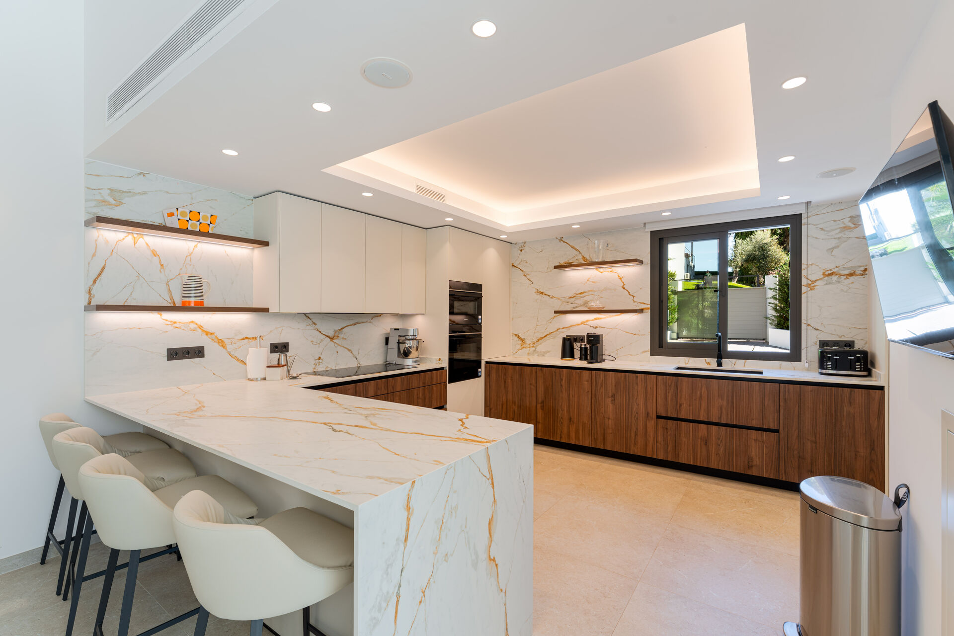 The kitchen, with a marble breakfast bar for four, walnut units and a built-in oven.