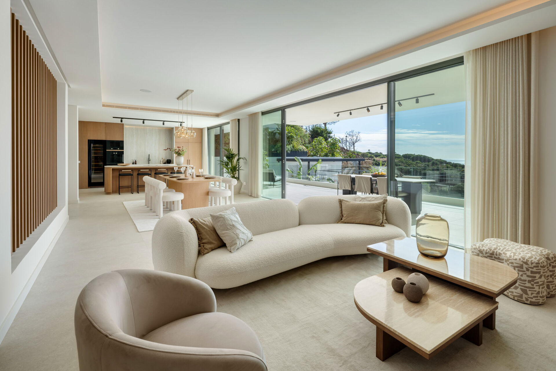 The living room, with a curved sofa and glass doors onto the terrace.
