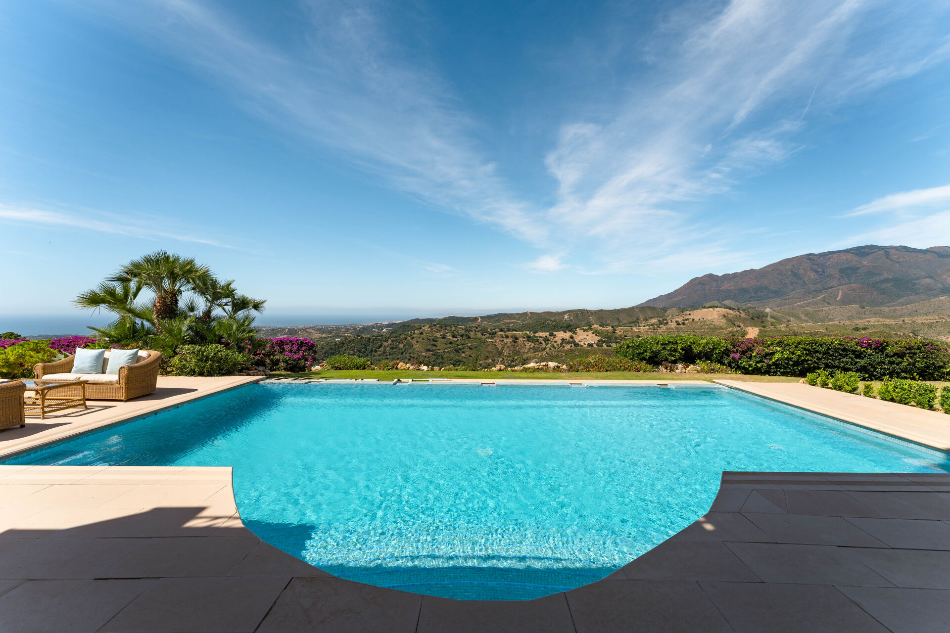 The swimming pool, with bougainvillea, the hills and a strip of sea on the horizon.