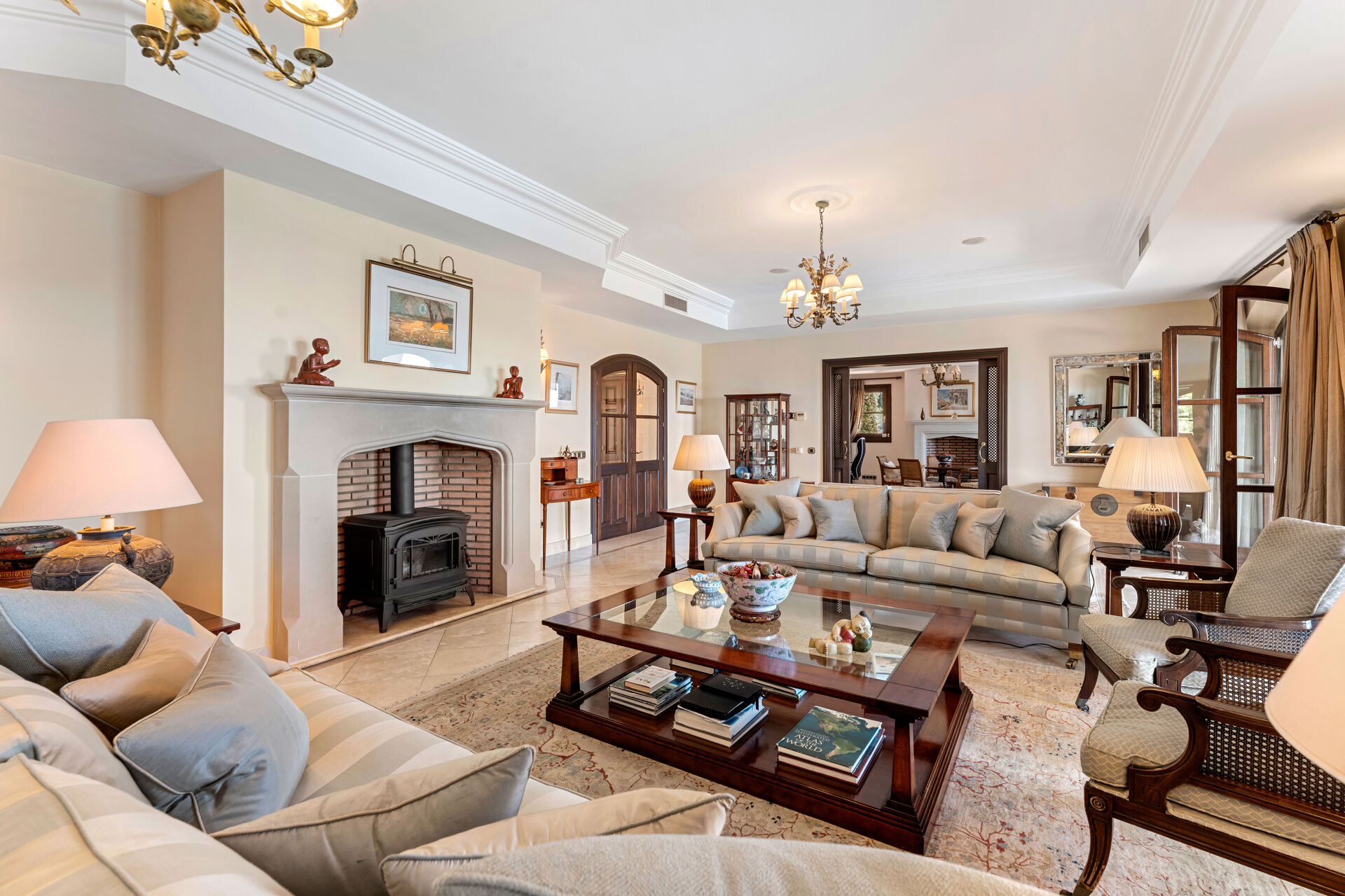 The main living room, with a stove in a stone fireplace, sofas and armchairs.