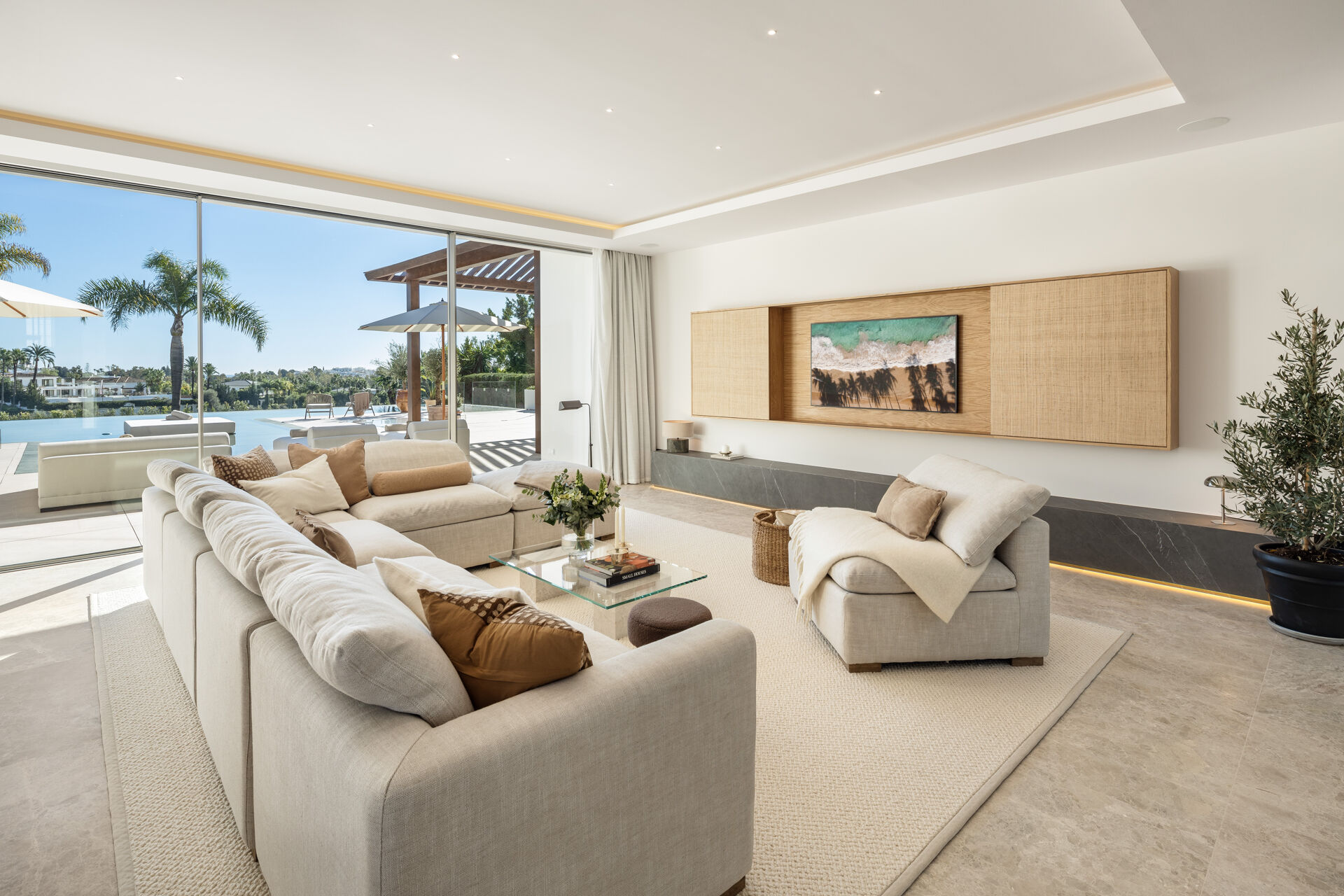 The living room, with a corner sofa and sliding glass doors opening onto the pool terrace.