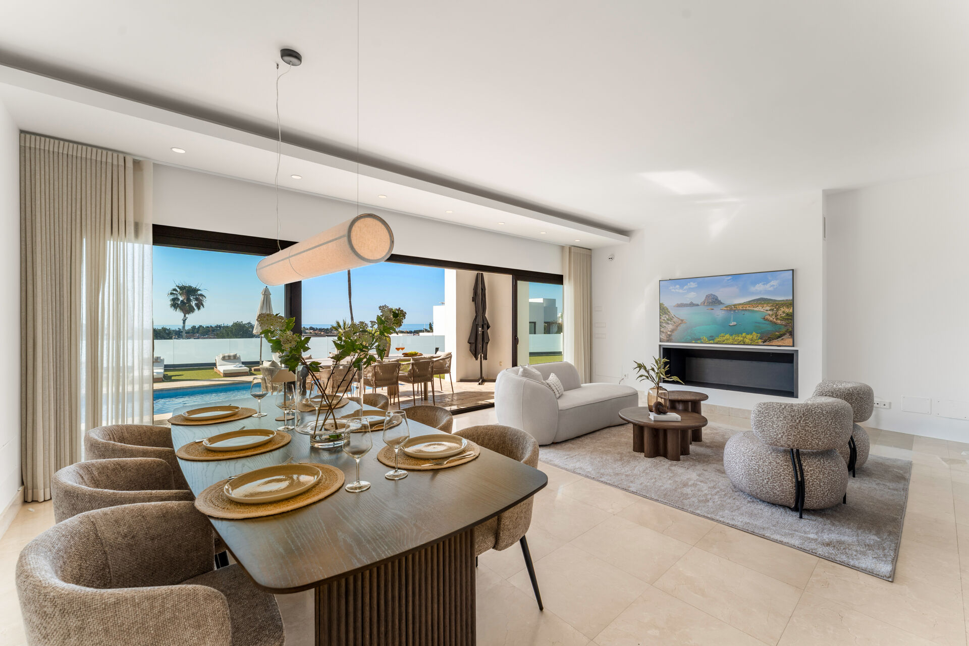 The dining area and living room, with sliding glass doors opening onto the terrace and the pool.