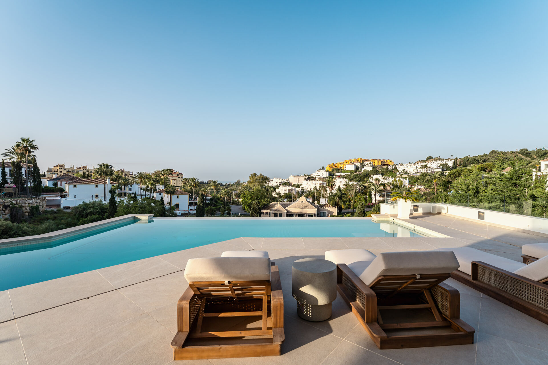 The pool and sun loungers on the terrace, looking over the neighbouring houses towards the sea.